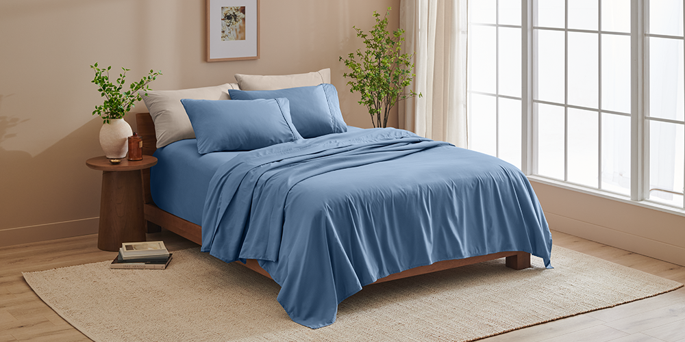 Bed styled with blue Ultra Soft 22 Inch Pocket Sheet Set near a sunlit window