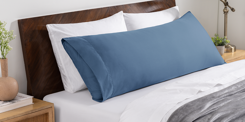 Bed styled with slate blue Ultra Soft Body Pillowcase and wood bed frame