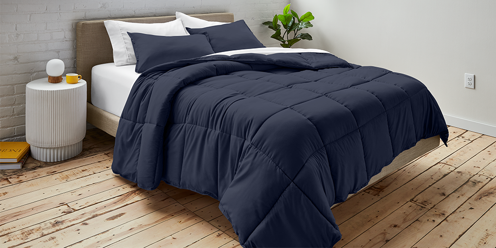 Bed styled with navy blue Ultra Soft Box Stitch Comforter Set and wood bed frame