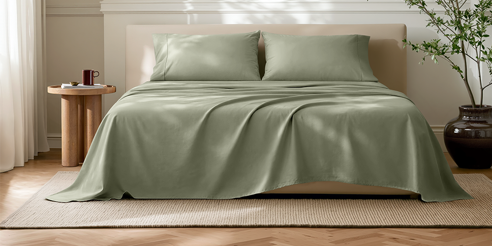 Bed styled with sage green Ultra Soft Neutrals Lights Sheet Set and wood nightstand