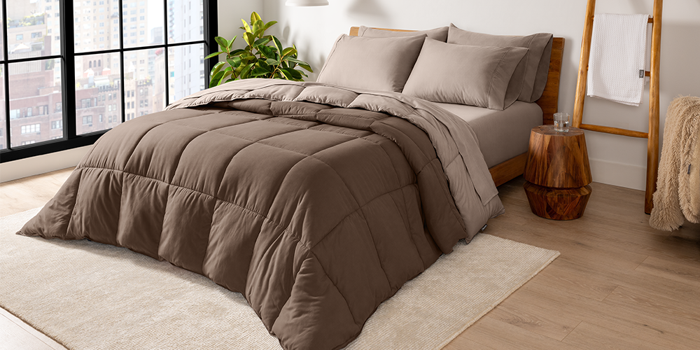 Bed styled with taupe Ultra Soft Reversible Bed In A Bag near a sunlit window