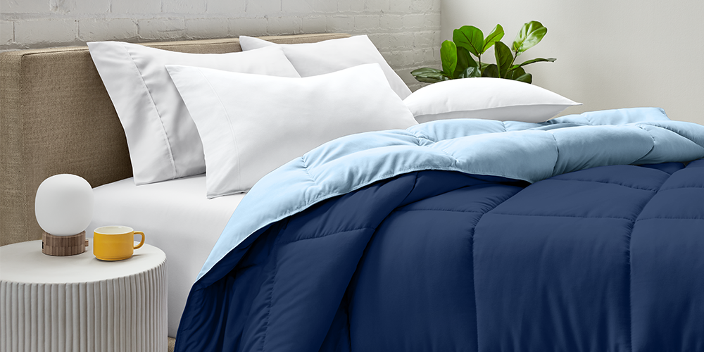 Bed styled with navy blue Ultra Soft Reversible Comforter and teal accent throw