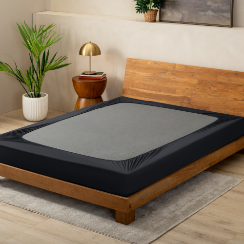Box spring with a dark gray cover on a wood bed frame