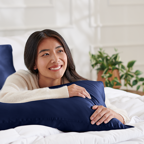 Woman relaxing in bed resting her head on a Mulberry Silk Body Pillowcase