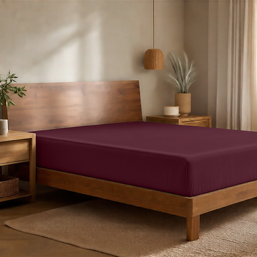 Bed with a burgundy bamboo fitted sheet