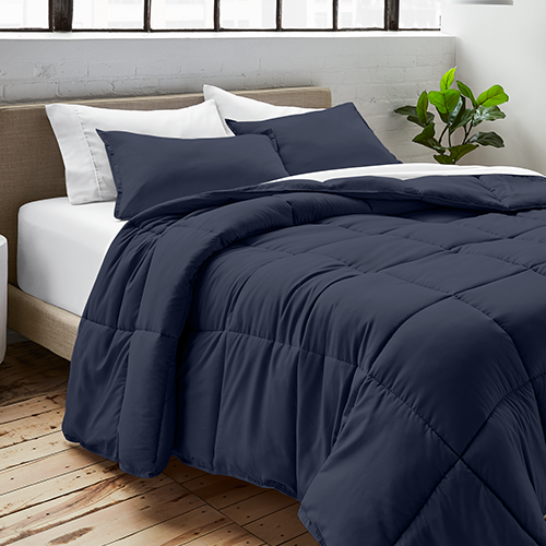 Bed styled with navy blue Ultra Soft Box Stitch Comforter Set, closer view
