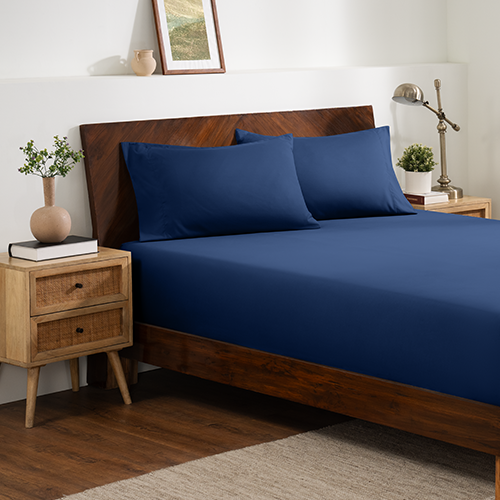 Bed with navy blue Ultra Soft Fitted Sheet with Pillowcase Set and wood bed frame