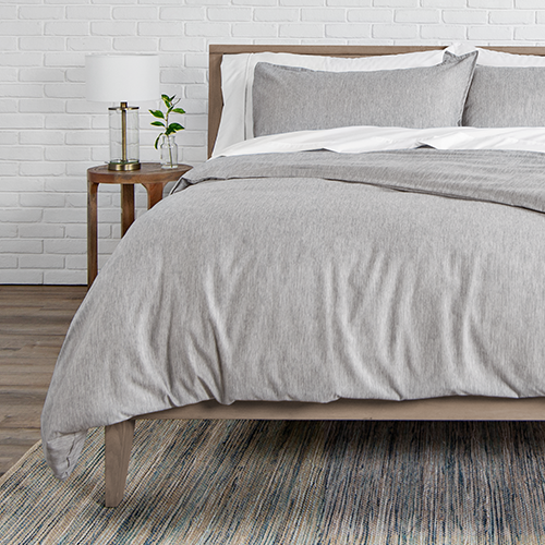 Bed styled with light gray heathered Ultra Soft Heather Duvet Cover Set and wood frame