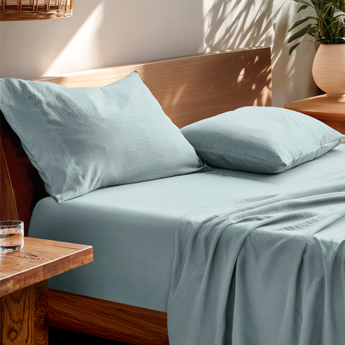 Bed styled with light blue Ultra Soft Washed Sheet Set and wood bed frame, closeup