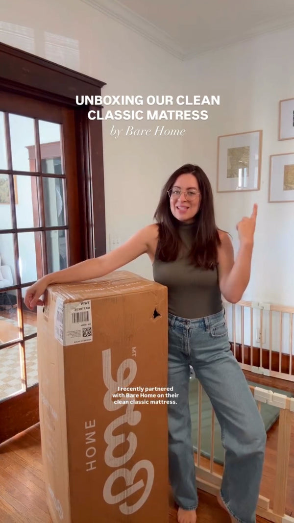 lady pointing #1 and holding a bare home mattress box