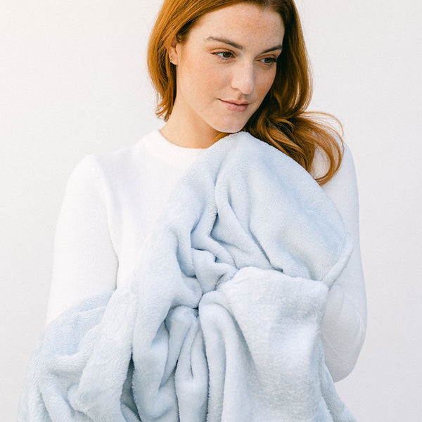 lady holding a microfiber blue blanket