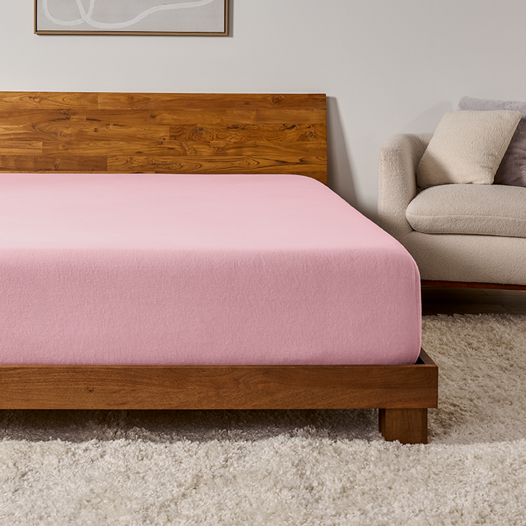 Bed with a pink flannel fitted sheet