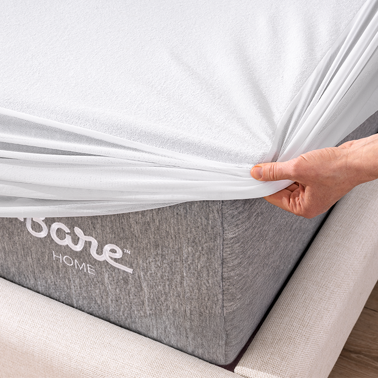 Closeup of white Cotton Terry Mattress Protector being fitted onto a mattress corner