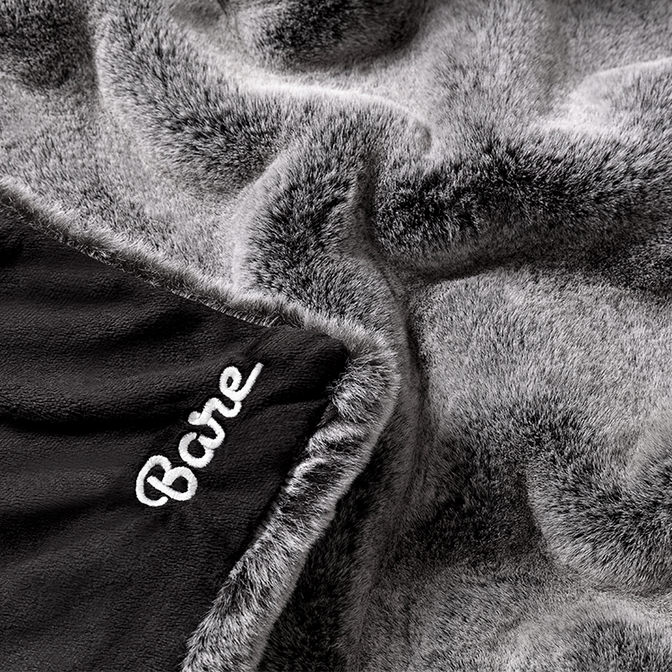 Close-up of gray faux fur blanket texture with a Bare Home tag