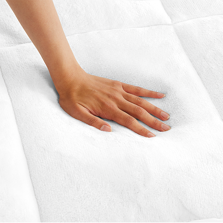 Hand pressing on white Reversible Mattress Pad fabric texture