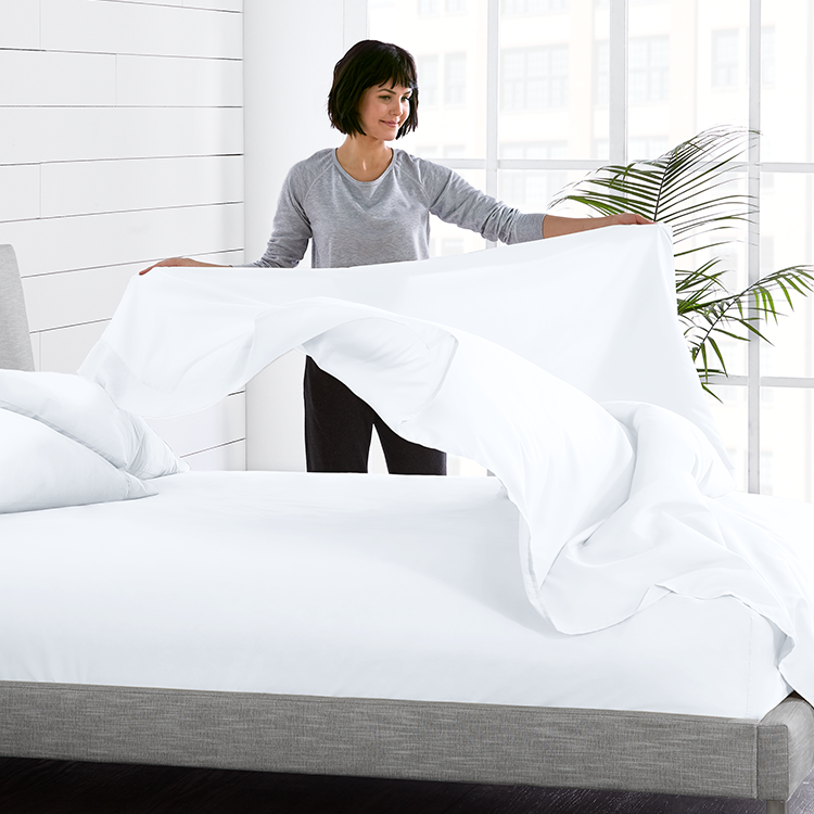 Woman making a bed with white Ultra Soft Flat Sheet