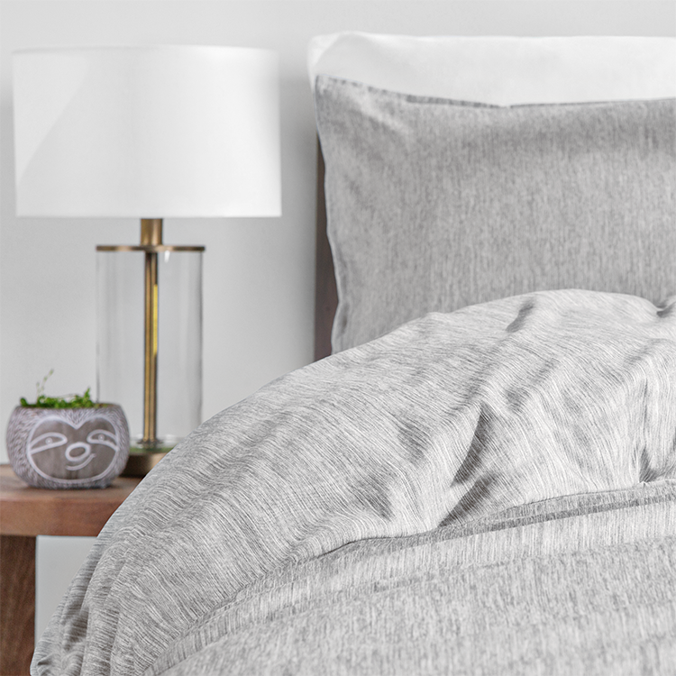 Bed with light gray heathered Ultra Soft Heather Duvet Cover Set, closeup with wood nightstand