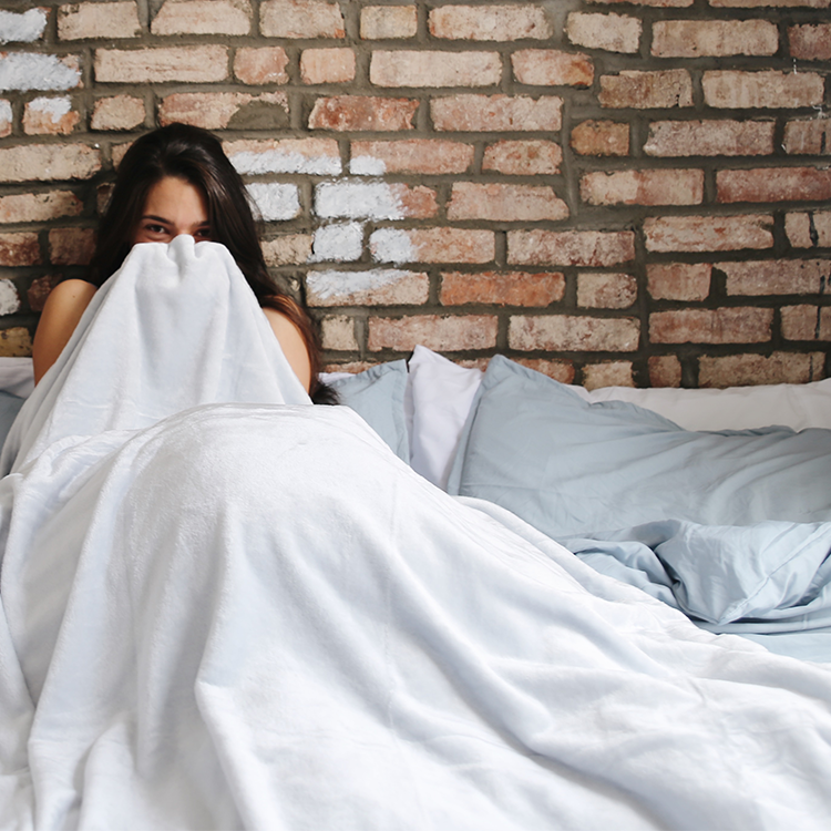 Bed styled with white Ultra Soft Washed Bedding Bundle in a bedroom with brick wall