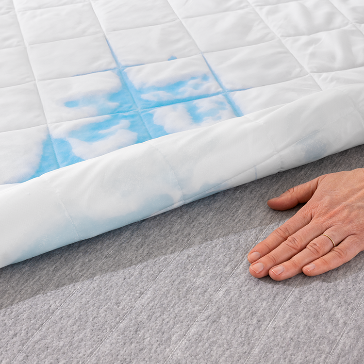 Hand touching light blue quilted Wrap Around Bed Skirt fabric