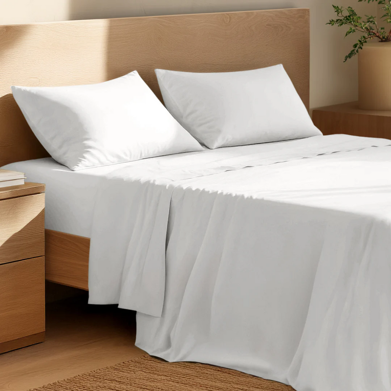 Bed with white and cream sheets and pillows