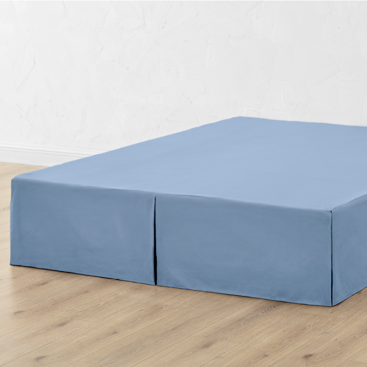 Bed with a blue pleated bed skirt