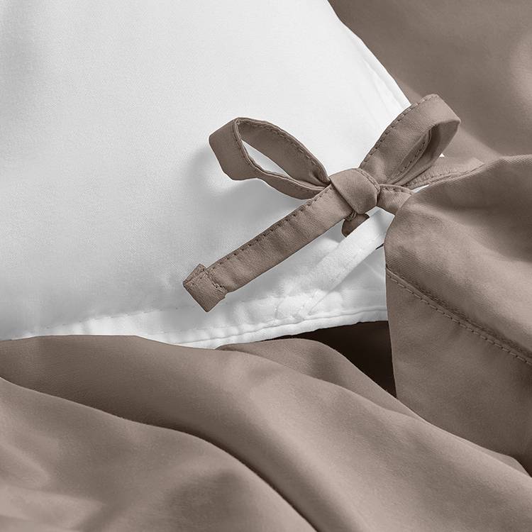 Closeup of taupe Organic Cotton Percale Duvet Cover Set fabric with ribbon tie