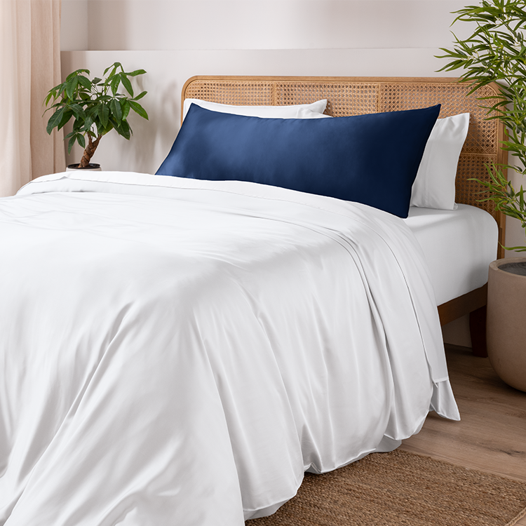Bed with a navy bamboo pillowcase and body pillow