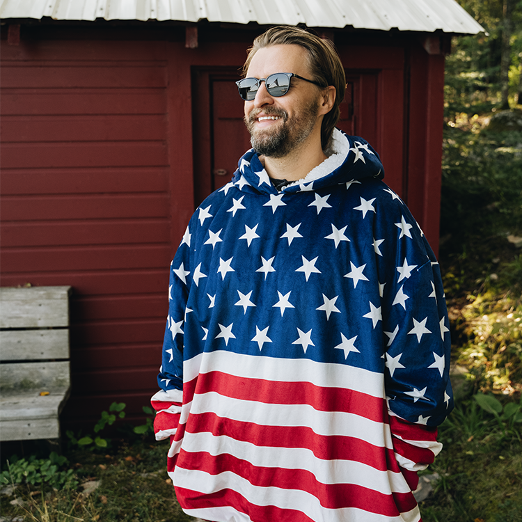 Man wearing an American flag print Bare Homey Wearable Blanket (Sherpa Adult) outdoors