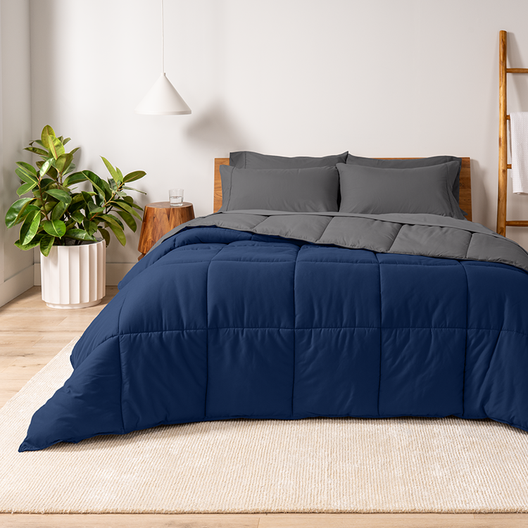 Bed with navy blue Ultra Soft Reversible Bed In A Bag, plant nearby