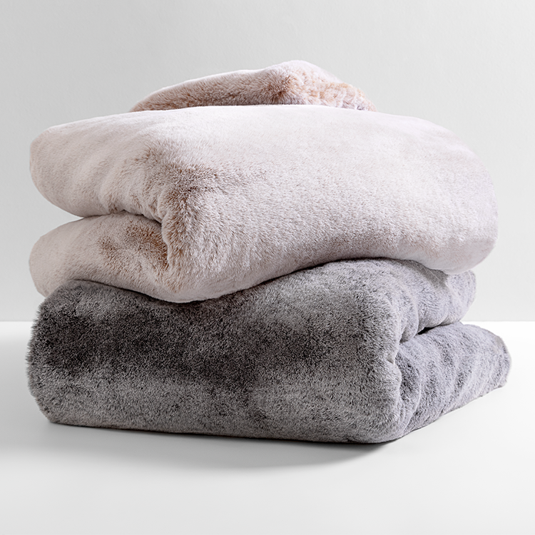 Close-up of folded gray faux fur blanket texture