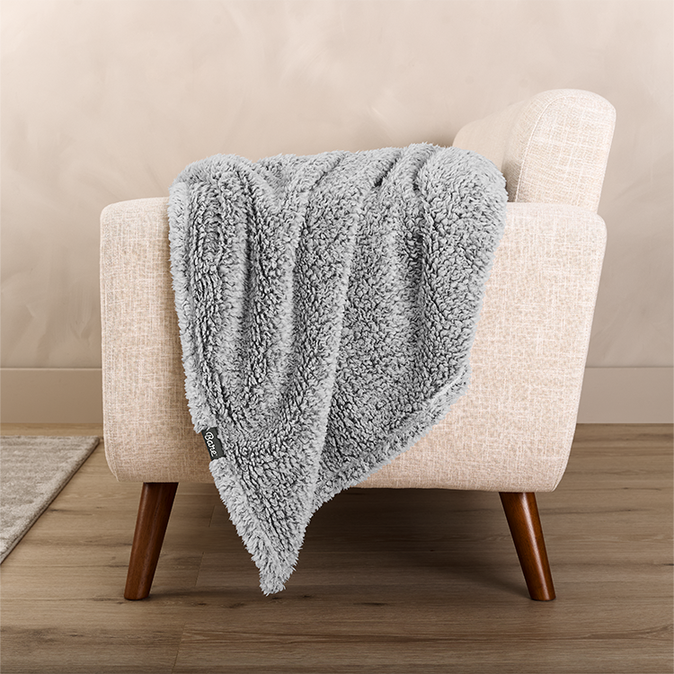 Tan tipped sherpa blanket draped on a chair