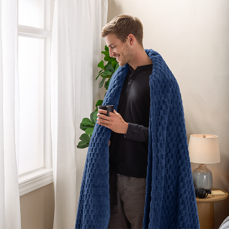 Person standing wrapped in a navy blue Microplush Waffle Blanket