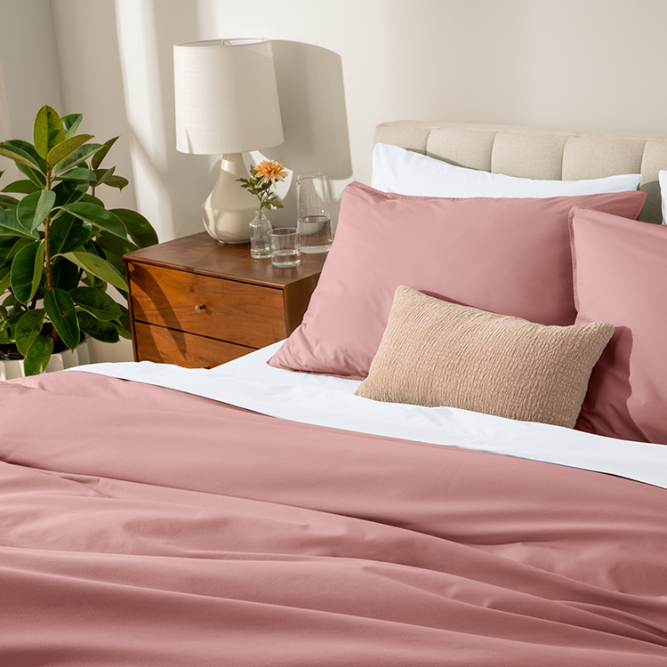 Bed styled with pink Organic Cotton Percale Dorm Bundle in a dorm room setting