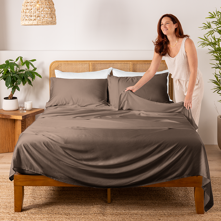 Bed with a tan bamboo pillowcase set and a person resting on it