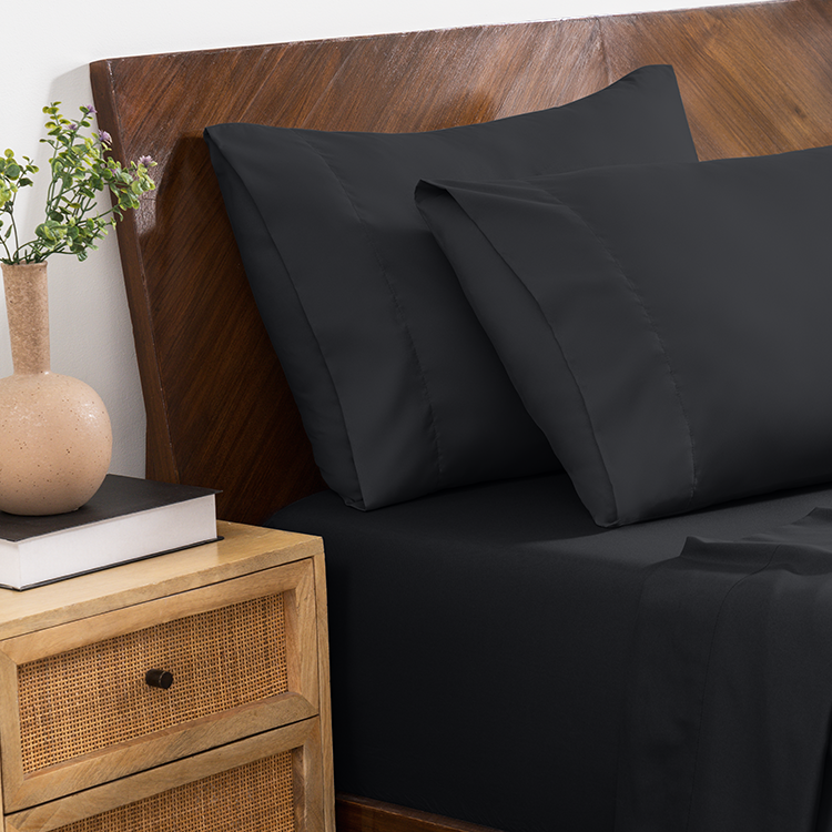 Bed styled with black Ultra Soft Envelope Pillowcase Set and wood nightstand