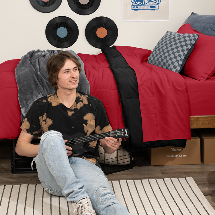 Woman sitting on a bed with red Ultra Soft Reversible Bed In A Bag