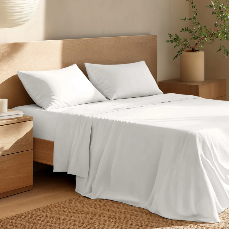 Neatly made bed with crisp white bed sheets