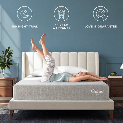 A woman lies stretched out on a light gray Bare Mattress on a bed with a cream tufted headboard in a styled bedroom. 