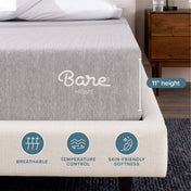 A close-up of a mattress with a light gray cover and a beige upholstered frame