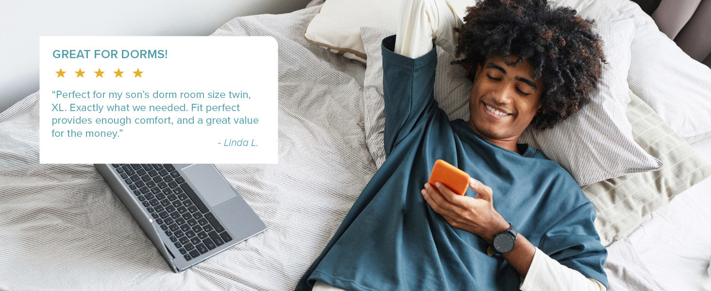 college student laying on a bed looking at his phone