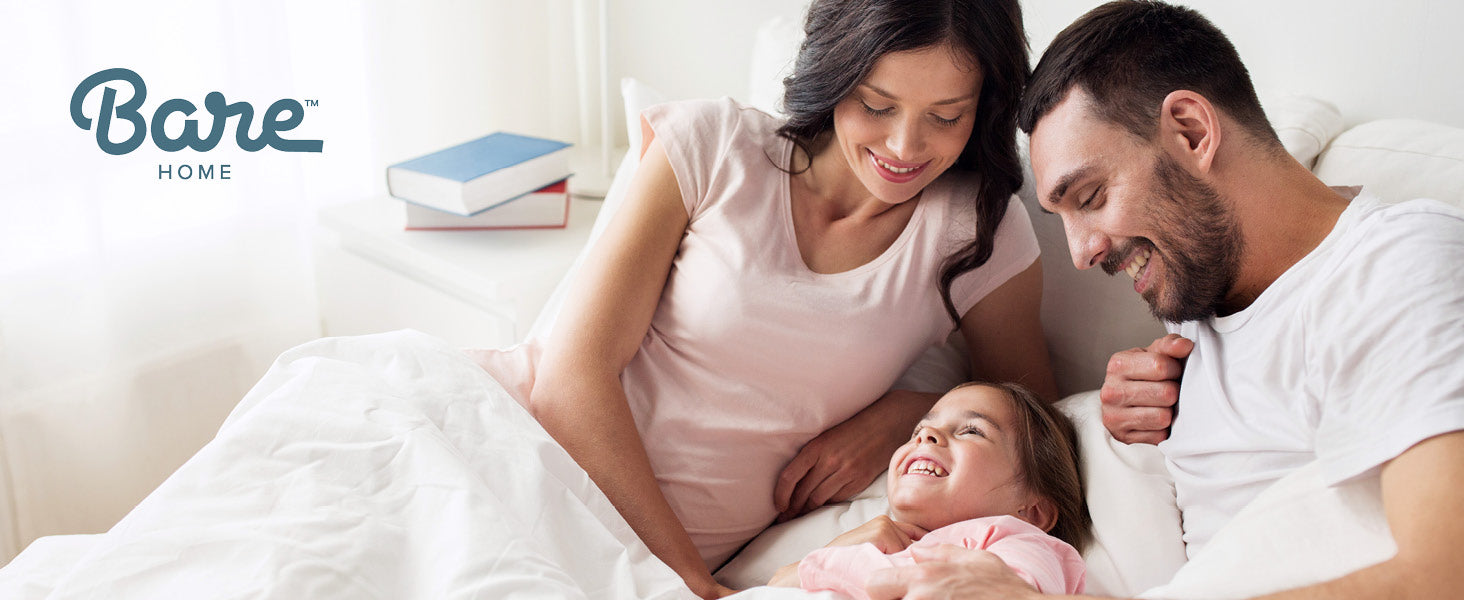 family snuggled up on a bed