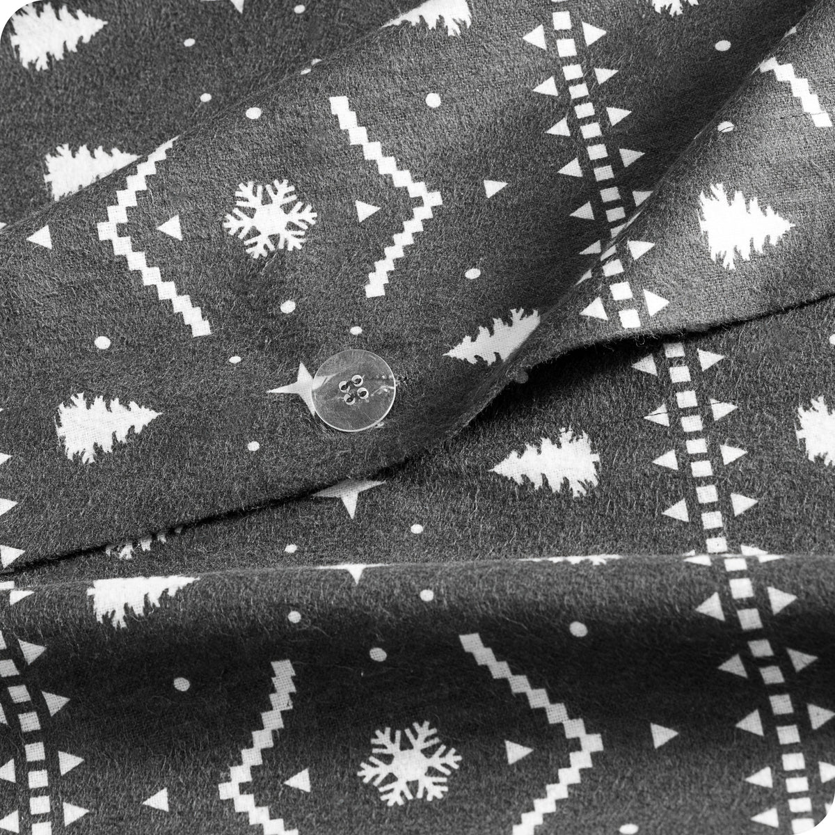 A close-up of dark gray fabric with a white winter pattern featuring snowflakes and Christmas trees