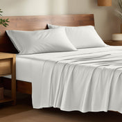 Bamboo bed sheets on a bed in a bedroom with night stands.