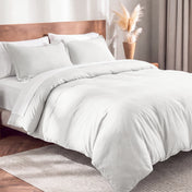 Flannel duvet cover set on a bed in a bedroom with a lamp and plant in the background.