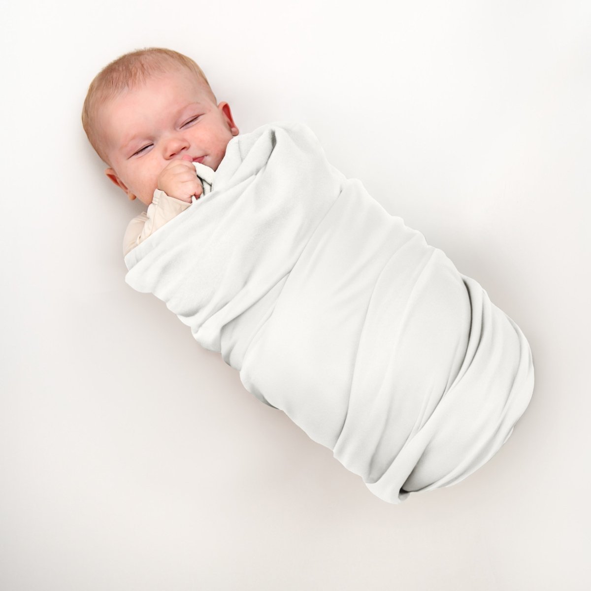 A baby wrapped in a flannel receiving blanket