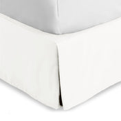 Bed skirt on a bed with white bedding