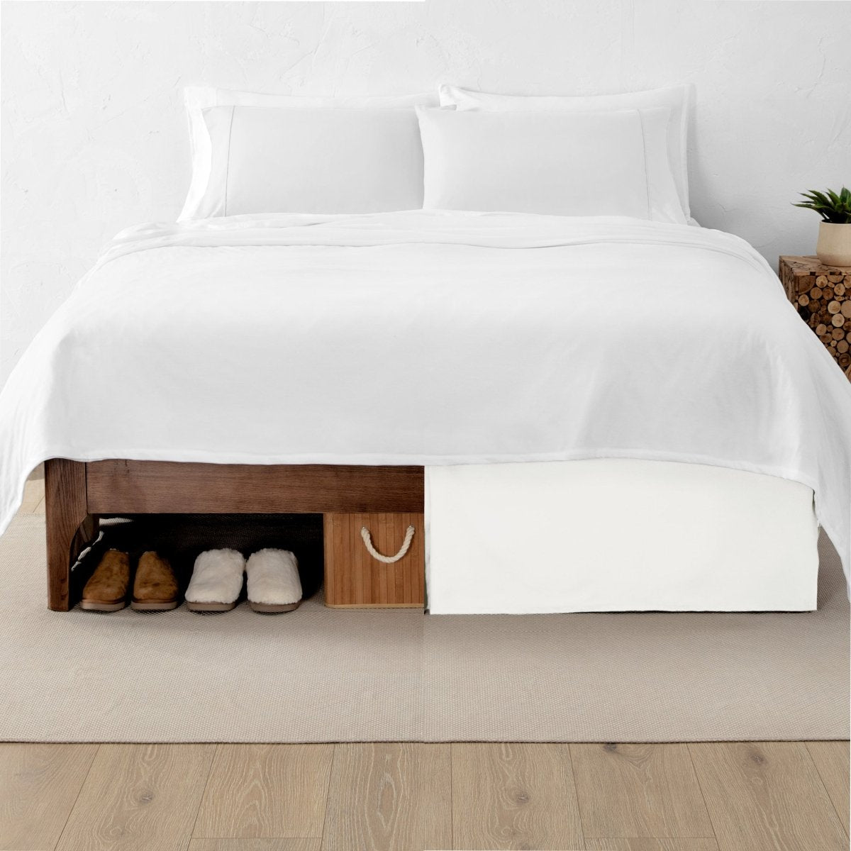 One side of a bed has shoes and a box under it while the other side has a bed skirt so that under the bed is hidden from view