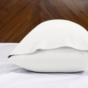 Body pillowcase with an envelope closure on a bed with a wooden headboard