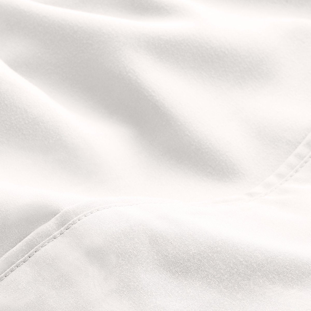 A close-up of microfiber fabric with soft folds and a visible stitched seam.