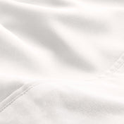 A close-up of microfiber fabric with soft folds and a visible stitched seam.